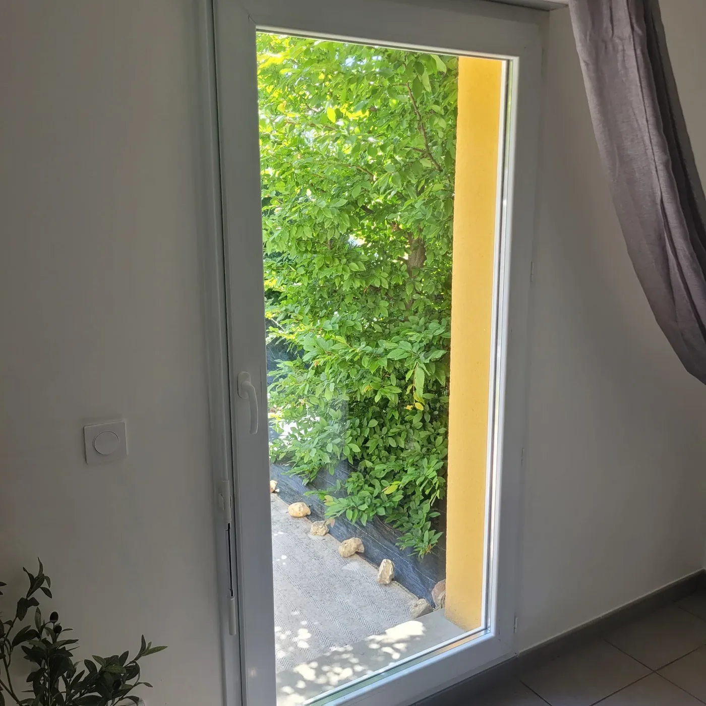 Porte-fenêtre vitrée donnant sur un jardin